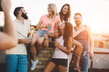 Grup arkadaşıyla birlikte eğleniyor. Çatı partide eğleniyor arkadaşlar.