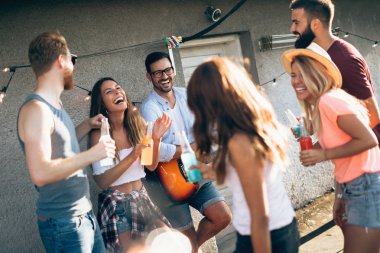 Grup arkadaşıyla birlikte eğleniyor. Çatı partide eğleniyor arkadaşlar.