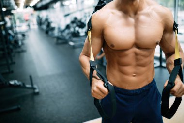 Spor salonunda egzersiz yapan genç yakışıklı güçlü erkek