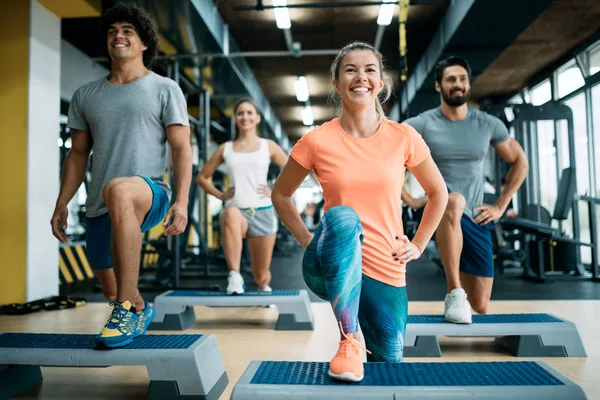 Bir grup genç insan birlikte spor salonunda yapıyor