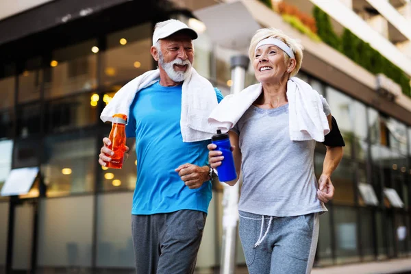 Healthy senior couple jogging in the city at early morning