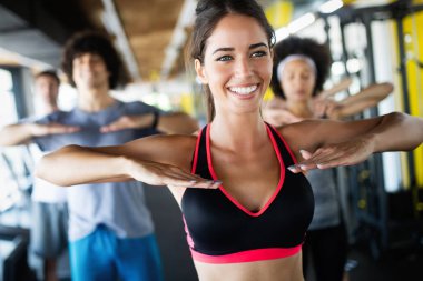 Spor salonunda egzersiz yapan bir grup sağlıklı genç.
