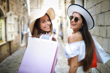 Mutlu kadın arkadaşlar yazın şehirde alışveriş yapan turistler.