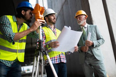 İnşaat mühendisi mimar ustabaşıyla inşaat alanını kontrol ediyor.