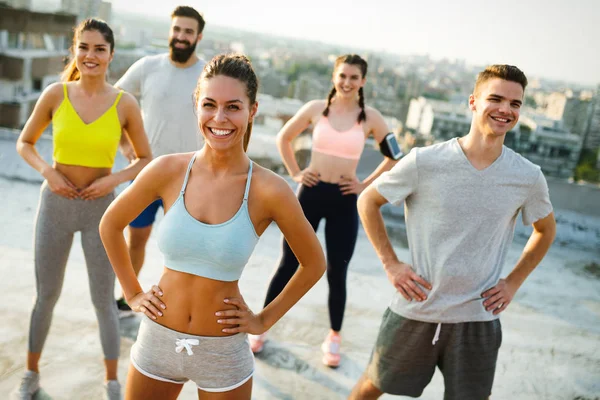 Fitness, sport, friendship and healthy lifestyle concept - group of happy friends or sportsmen exercising