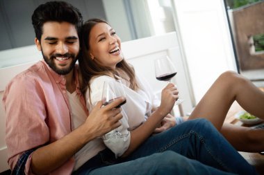 Güzel bir çift yatak odasında birlikte vakit geçirirken gülümsüyor, konuşuyor ve sarılıyor.