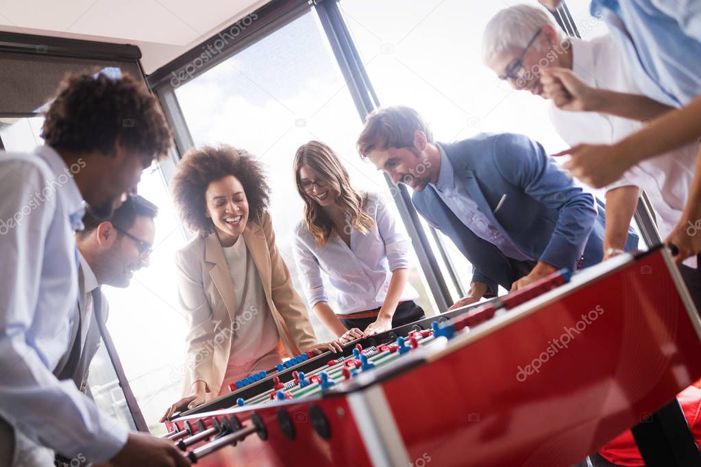 Coworkers playing table football and ralaxing on break from work