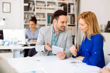 İş adamları ofiste yeni fikirler üzerinden işbirliği yapıyor ve konuşuyorlar.