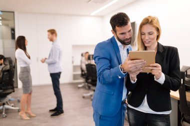 İş adamları ofiste dijital tablet kullanırken tartışıyor