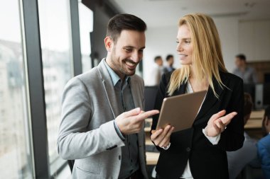 İş adamları ofiste dijital tablet kullanırken tartışıyor