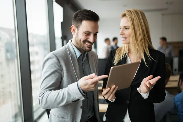 İş adamları ofiste dijital tablet kullanırken tartışıyor