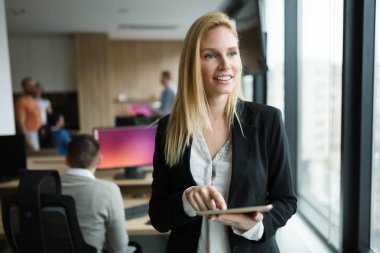 Modern ofiste dijital tablet kullanan çekici bir iş kadını