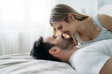 Yatak odasında genç çekici sevgi dolu çift portresi