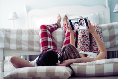 Genç mutlu çift yatak odasında dijital tablet kullanma