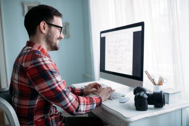 Evde projede çalışan genç çekici Tasarımcısı