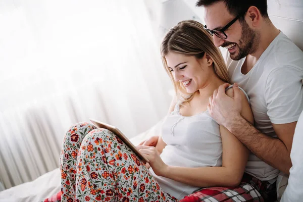 Unga Lyckliga Paret Använder Digitala Tablett Sovrum — Stockfoto