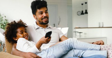 Baba ve kızı birlikte oyun odası televizyon izlerken