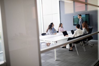 Bir grup mimar ve iş adamı birlikte çalışıyor ve beyin fırtınası yapıyorlar.