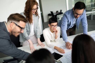 Bir grup mimar ve iş adamı birlikte çalışıyor ve beyin fırtınası yapıyorlar.