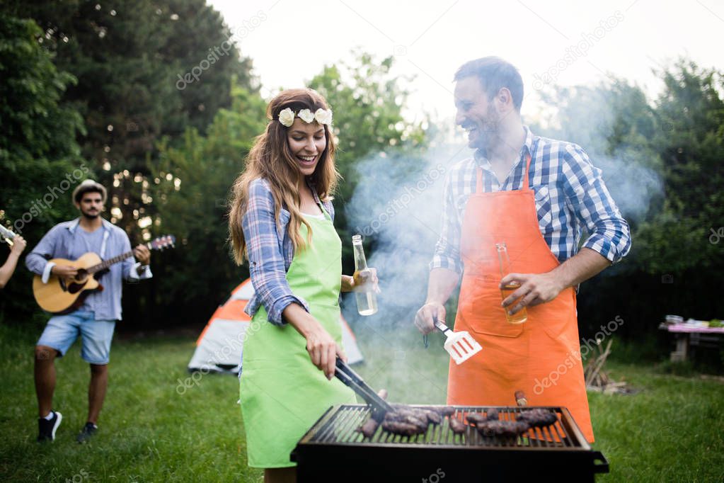 Friends having a barbecue party in nature while having fun