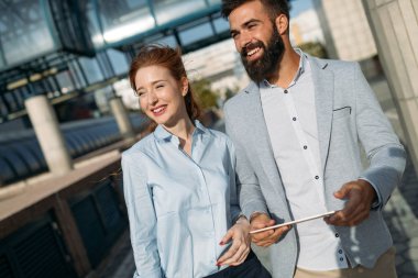 İş arkadaşları şehir sokaklarında yürüyüp konuşuyor