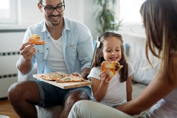 Portrait of happy family sharing pizza together at home