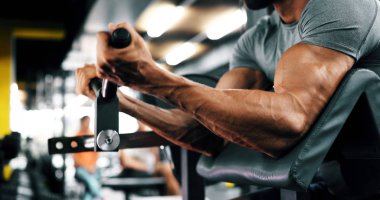 Güçlü adam eğitim bicepses spor salonunda sökük.