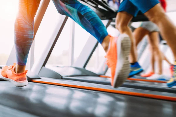 Group of friends exercising on treadmill machine in gym