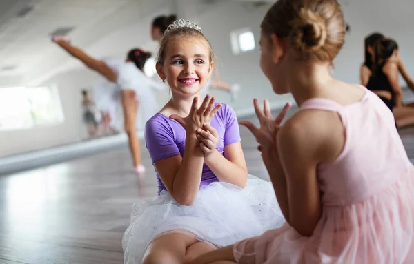 Group of fit little ballerinas doing exercises in dance school