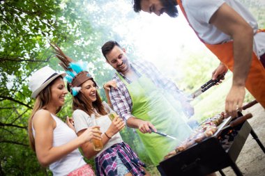 Bir grup arkadaş dışarıda barbekü partisi veriyor ve birlikte eğleniyorlar.