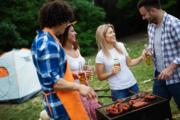 Friends having a barbecue party in nature while having fun