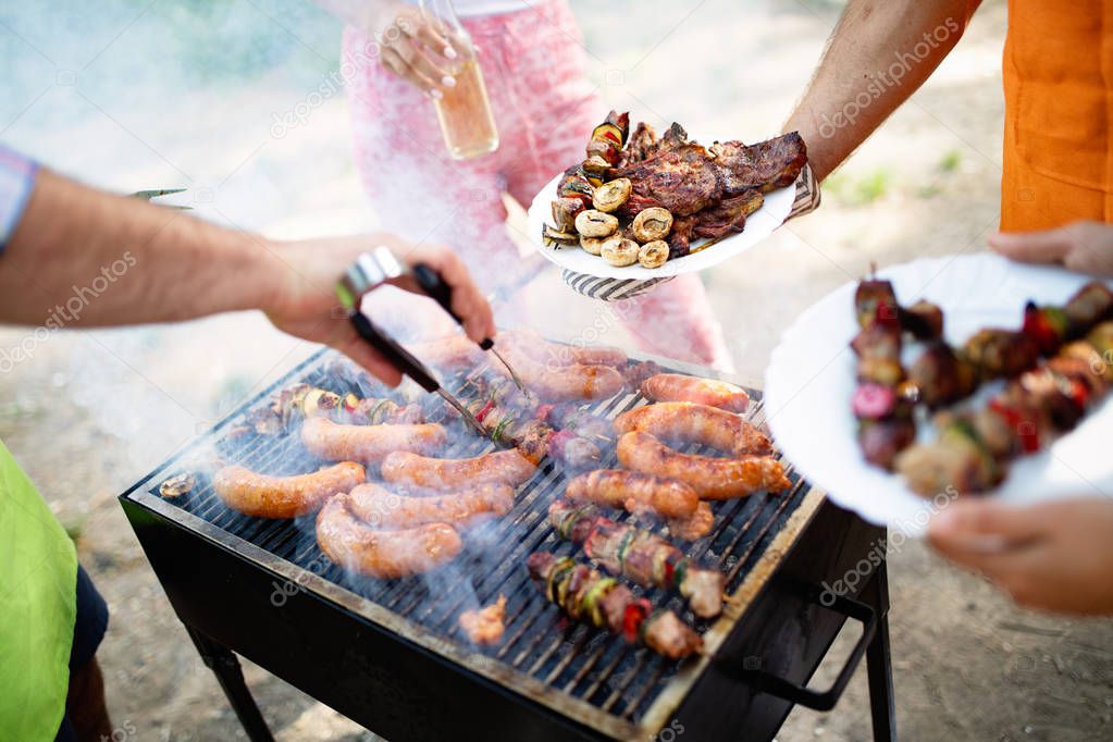 Group of friends camping and having a barbecue in nature