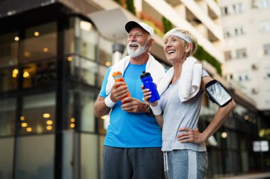 Yaşlı çift enerjilerini tazelemek ve su içmek için su içer.