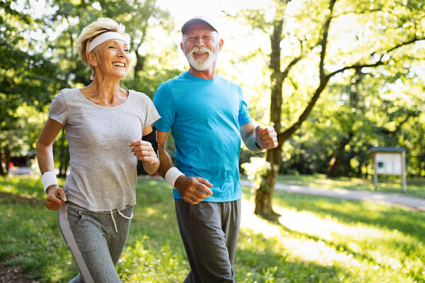 Beautiful sporty senior couple staying fit with running and jogging