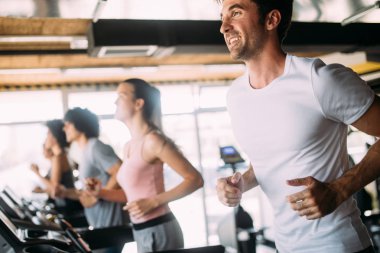 Spor salonunda egzersiz yapan bir grup genç.