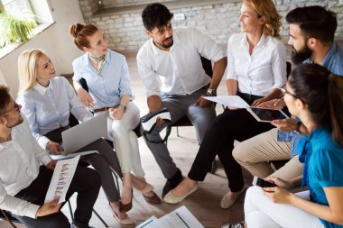Bir grup genç iş adamı toplantı yapıyor. Ofisteki toplantıda gülümseyen bir grup genç tasarımcı..