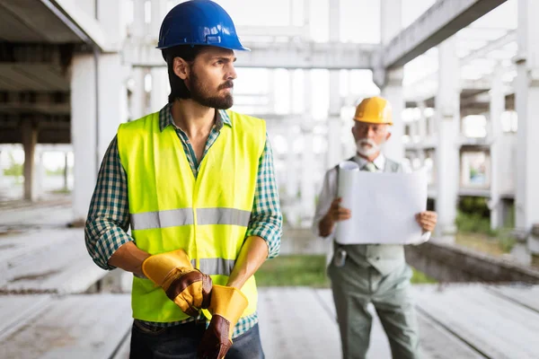 Engenheiro e gerente do canteiro de obras que lida com plantas e planos — Fotografia de Stock