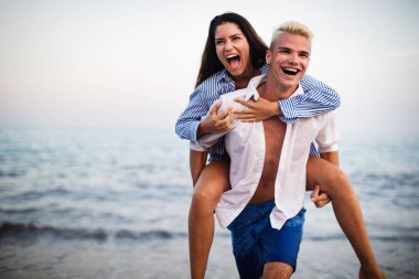 Mutlu genç çift eğleniyor ve sahilde aşk