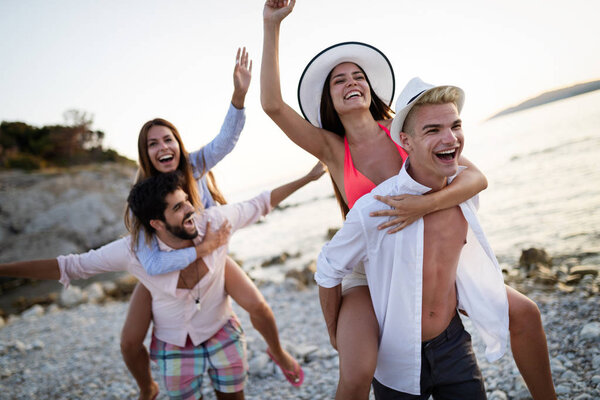 Cheerful couples friends enjoying weekend and having fun on beach