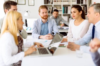 İş adamları ofiste yeni fikirler üzerinden işbirliği yapıyor ve konuşuyorlar.
