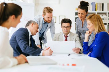 İş adamları ofiste yeni fikirler üzerinden işbirliği yapıyor ve konuşuyorlar.