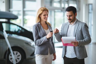 Araba galerisinde yeni alıcıya satan profesyonel satış temsilcisi
