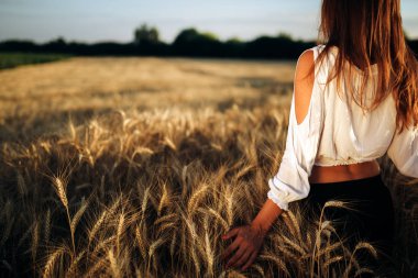 Genç, güzel, mutlu bir kadın doğada vakit geçiriyor.