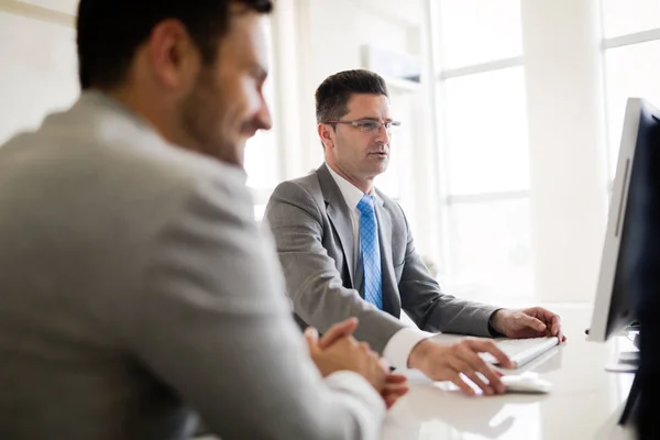 Image of two handsome businessmen using computer at meeting — Stock Photo, Image