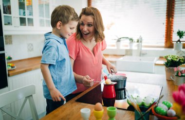 Aile, anne ve oğlu eğlenceli sahip boya ve yumurta tatil için süsleyin