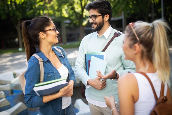 Happy group of students studying and talking together at university