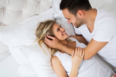 Yatak odasında romantik kez sahip genç mutlu çift