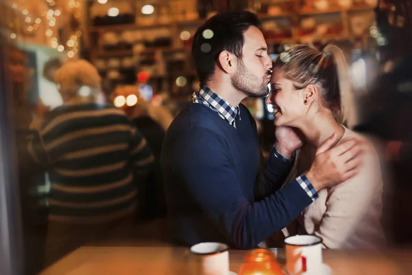 Счастливая пара целуется в баре и встречается — стоковое фото