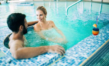 Mutlu çekici çift rahatlatıcı spa yüzme havuzunda