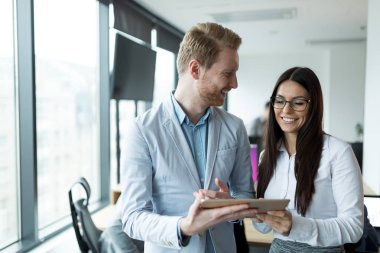 İş adamları ofiste dijital tablet kullanırken tartışıyor